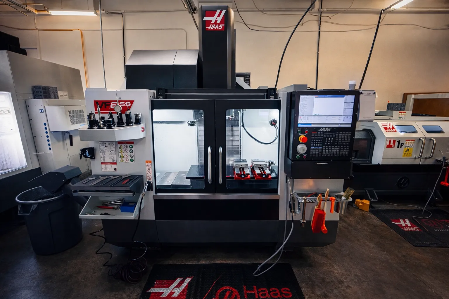 Haas VF-2SS vertical machining centre with vises fixtured on the table for a milling run