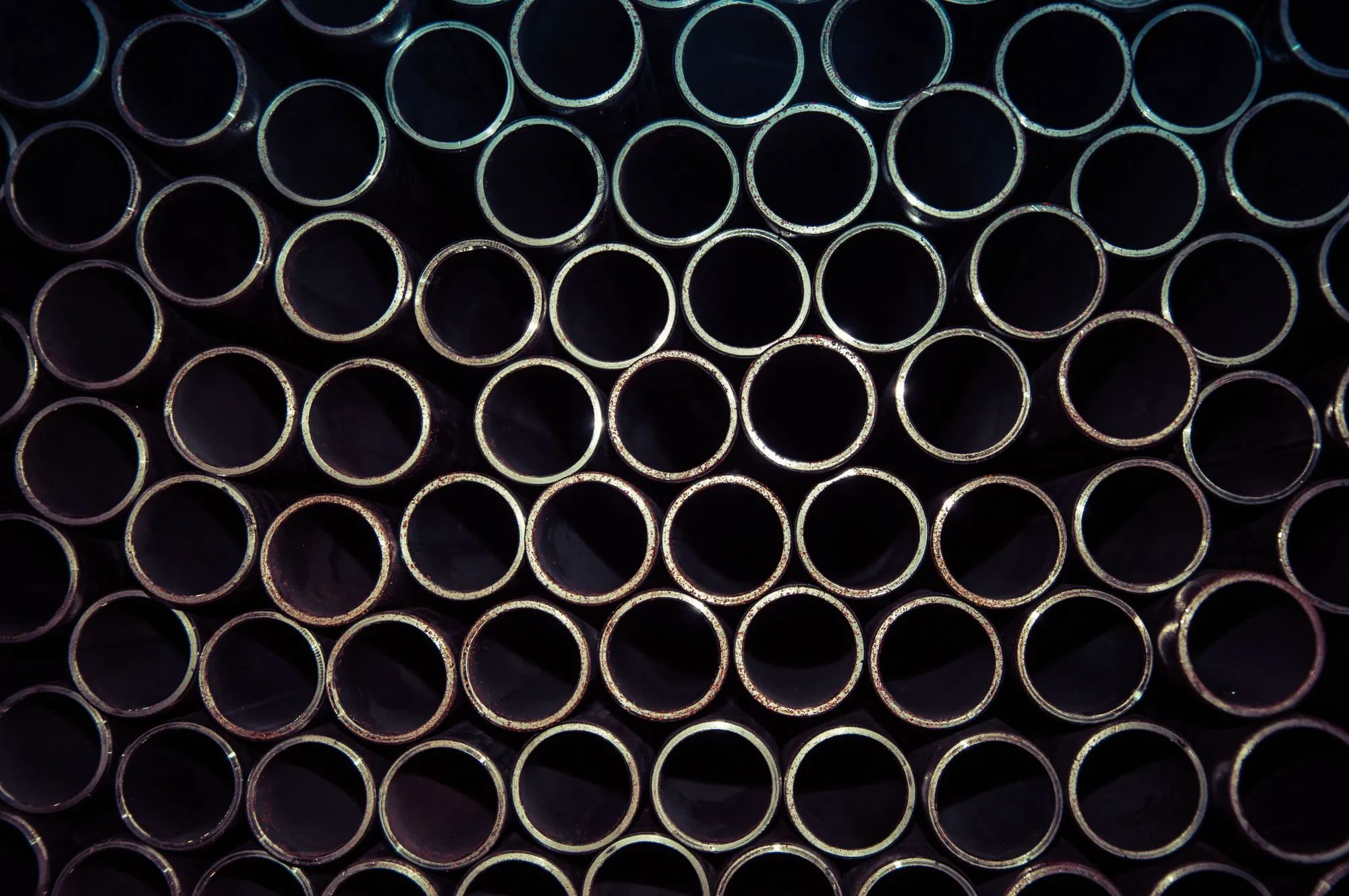Stacked ends of round metal bar stock, showing the range of alloys a machine shop holds